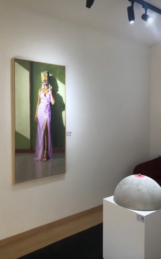 Painting of a woman in a violet dress beside a concrete sculpture.