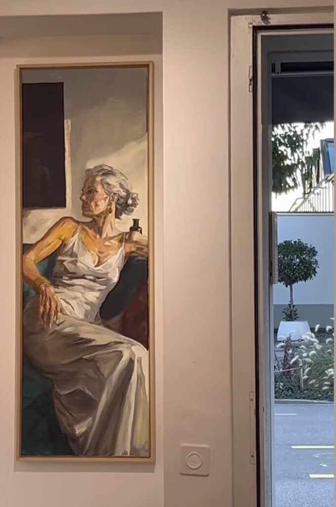 Portrait of a woman beside a gallery window overlooking the street.